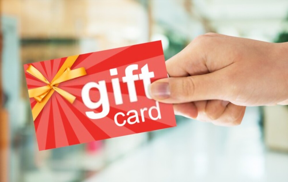 a woman's hand holding a gift card